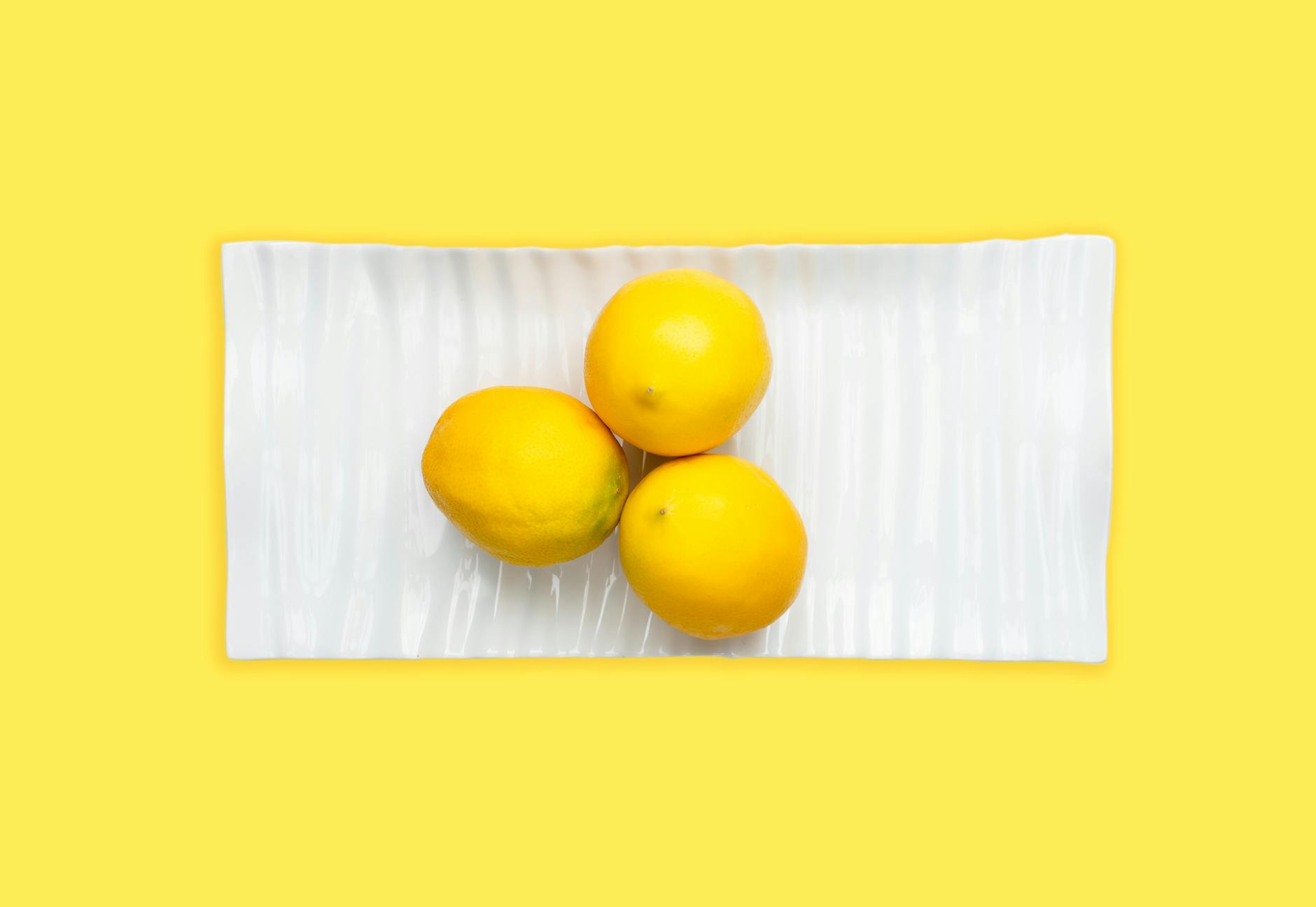 Fresh lemons on a white plate, symbolizing cyclical variation and natural rhythm