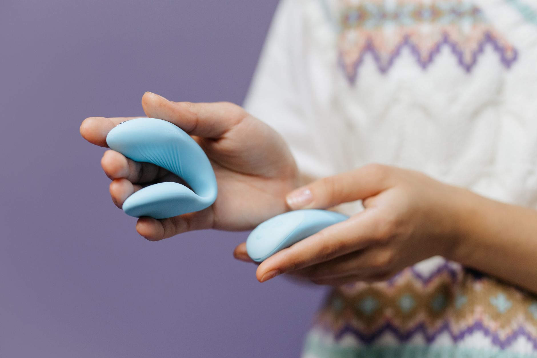 Close-up of hands holding a sleek blue vibrator, symbolizing reclaiming personal pleasure and autonomy